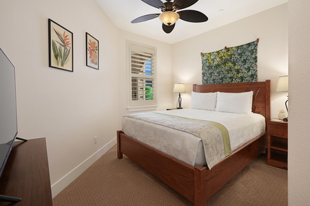 Relax in your serene queen bedroom with tropical touches, comfortable furnishings, and a cooling ceiling fan for peaceful nights.