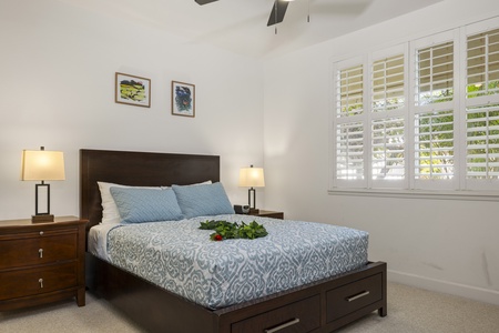 A comfortable queen bed, plantation shutters, and soft natural light create a relaxing retreat at the end of each day.