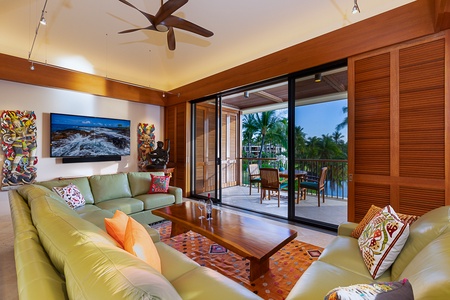 Relax in the elegant living room with floor-to-ceiling windows and sweeping views of the tropical landscape.