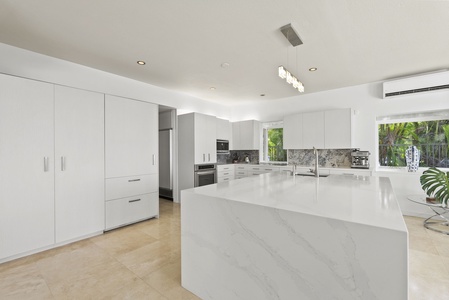 Entertain with ease in the gourmet kitchen—featuring premium appliances, marble counters, and an expansive island ideal for prepping or gathering.