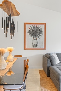 Natural textures and bold island art give the space a relaxed, curated feel.
