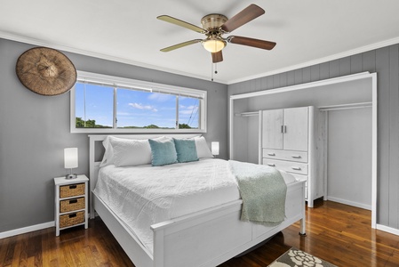 Rest easy in this serene guest room with a plush king bed and large window framing lush views.