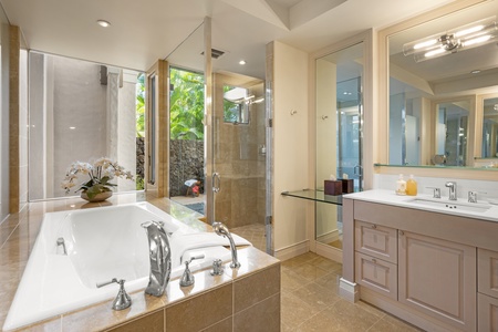 Unwind in your spa-like bathroom with a deep soaking tub, glass-enclosed shower, and tropical outdoor shower.