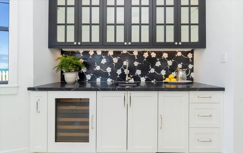 Stylish beverage bar with glass cabinetry and wine fridge for effortless hosting.