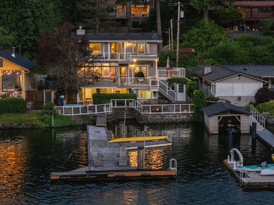 The residence glowing gold at dusk, mirrored in the still lake below.