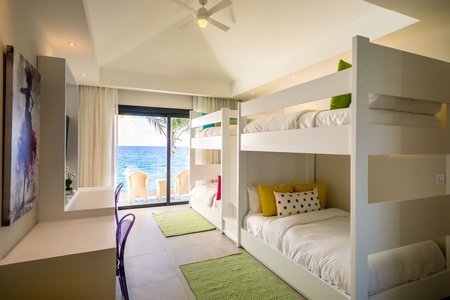 Relax in this vibrant guest bedroom with ocean views and ample space.