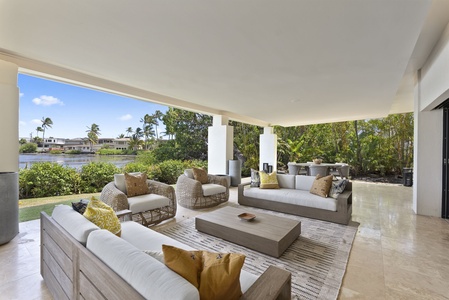 Dine with a view at Honolulu Lagoonfront Villa—oversize windows frame lush tropical surroundings in this elegant dining space.