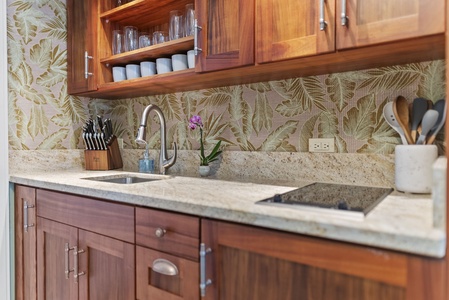 Chic kitchenette featuring natural wood finishes, tropical decor, and a cozy cooking space.