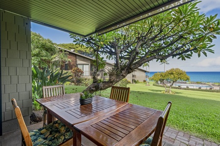 Dinner on the covered lanai, the lawn rolling out to open water.