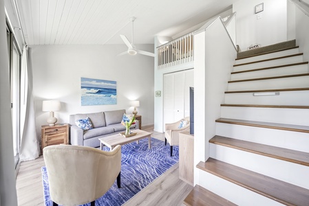 Stairs climb from the living area up to the lofted sleeping space above.