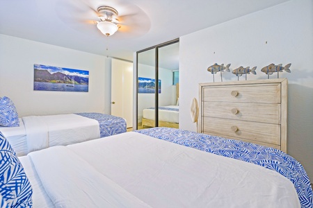 A restful second bedroom at Papakea K-105, filled with soft light, storage, and island charm.