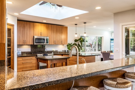 The kitchen features a spacious center island and rich wood cabinetry.