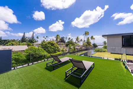 Unwind on the oceanfront lawn with loungers, open sky, and coastal views.