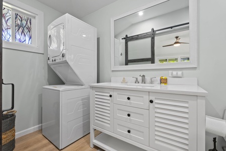 This efficiently designed space combines a full-sized washer and dryer with a spacious bathroom vanity.