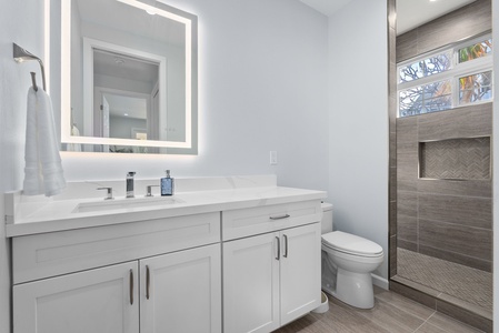 Full bath with expansive vanity, LED mirror, and under-cabinet storage—a blend of function and elegance.