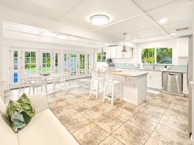 Your bright, airy kitchen flows seamlessly into tropical outdoor paradise through stunning French doors, creating the perfect indoor-outdoor entertaining space.