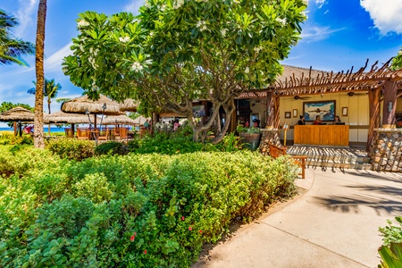 Enjoy a refreshing drink at the charming beachside bar at Duke’s Beach House, just steps from Honua Kai Konea 232.