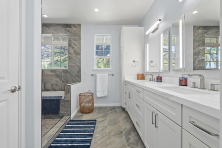 Spa-inspired en-suite bathroom with floor-to-ceiling tile and scenic window views.