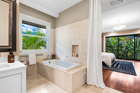 Spa-style soaking tub with garden views and natural stone surround.