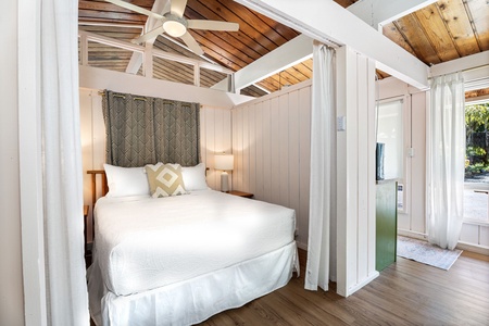 Drift into peaceful sleep beneath rustic wooden beams in your charming canopy bed, wrapped in soft white linens.