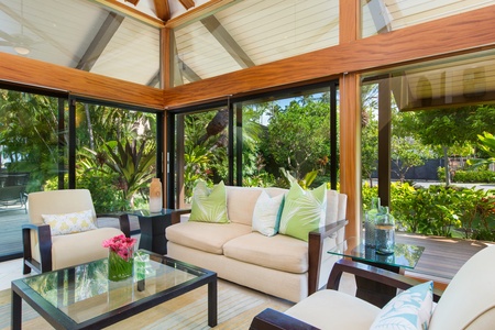 Lounge in the bright guest house living room surrounded by tropical garden views.