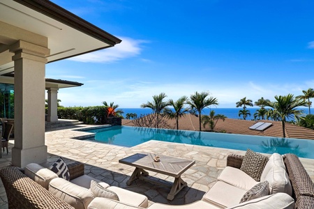 Spacious pool deck with loungers and panoramic views of the Kona coastline.