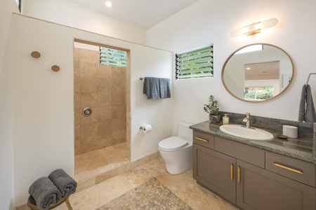 The private bath for Bedroom Four includes a sleek walk-in shower and floating vanity—combining style and privacy.