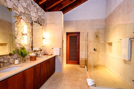 Elegant ensuite bathroom with a glass-enclosed shower and stone accents.