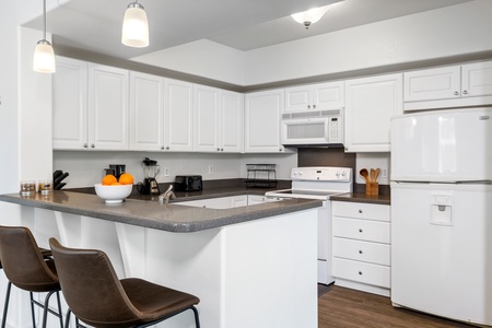 The fully-stocked kitchen has ample counter space and cabinetry to prepare meals conveniently.