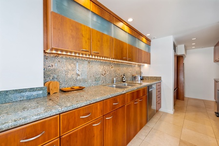 Long, modern kitchen with high-end finishes and plenty of counter space, creating a chef’s dream environment.