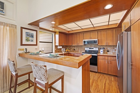 Kapalua Ridge 2321’s kitchen features sleek appliances and a cozy bar for casual dining or evening drinks.