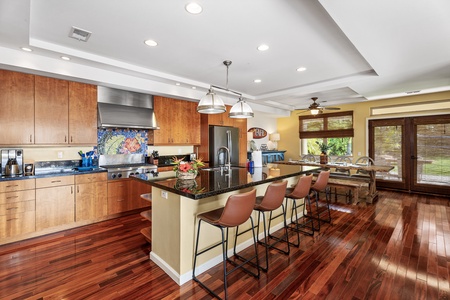 Spacious gourmet kitchen with a central island and bar seating for four, perfect for socializing while cooking.