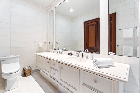 You'll love freshening up in this pristine bathroom with dual sinks, elegant marble counters, and fluffy towels waiting for you.