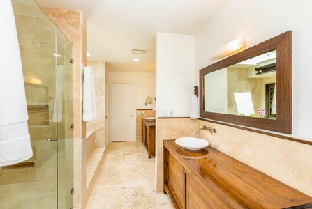 Indulge in a spa-like ensuite with dual vanities, a walk-in shower, and natural stone finishes.