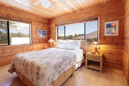 Cozy queen bedroom with warm wood finishes and garden views.