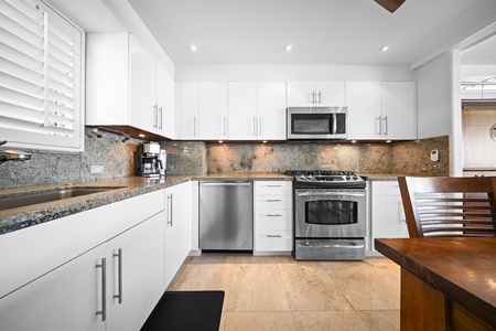 The open kitchen and dining area flow seamlessly into the living space, making it easy to gather for meals after a day at Kaimana Beach.
