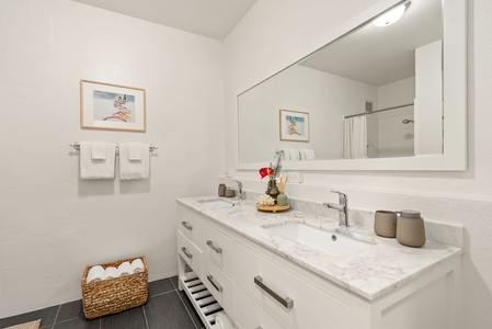 Refresh in your bright, modern bathroom with soft towels and thoughtful touches waiting on the marble vanity. Everything you need for a comfortable stay is right here.