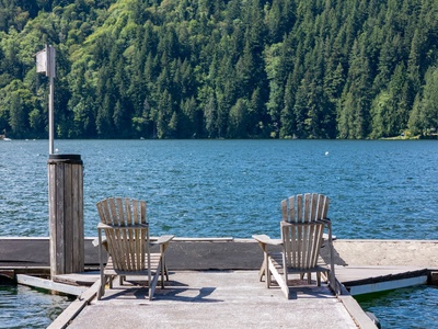 Two Adirondack chairs at the end of a private dock, Lake Samish spread out in front of you and nothing on the agenda.