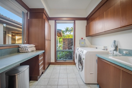 Convenient laundry room with a washer, dryer, and sink for easy cleanup.