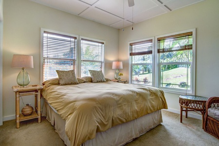 Bedroom 3 has a king sized bed and windows looking out to the front expanse of lawn.