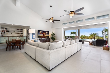 Contemporary living room with dual ceiling fans and plush seating, designed for family gatherings, movie nights, or simply relaxing in paradise.