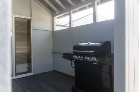 Outdoor BBQ area with a grill, perfect for cooking up fresh island flavors in the ocean breeze.