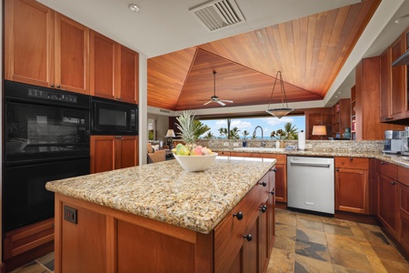 Ocean view kitchen with gleaming granite countertops and top tier appliances.