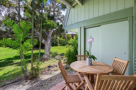 Shaded garden lanai with bistro seating, perfect for morning coffee or evening BBQs.