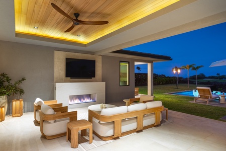 Elegant covered living space where modern comfort meets tropical luxury, complete with fireplace and pool views.