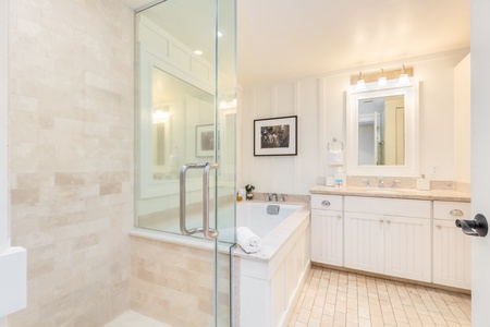 Elegant bathroom with a soaking tub, glass shower, and soft neutral finishes