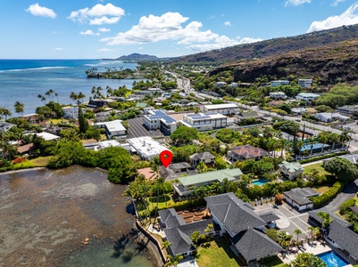Zoomed aerial shows proximity to the lagoon, beach access, and lush residential surroundings—an Oahu hidden gem.