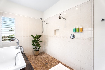 Open walk-in shower with built-in bench and dual heads, designed for ease, relaxation, and rejuvenation after a sun-filled day.
