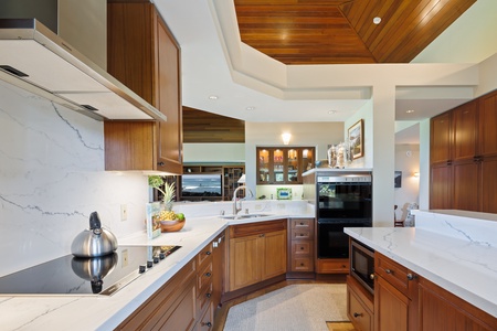 Your gourmet kitchen awaits with warm wood cabinetry, marble countertops, and premium appliances for creating memorable meals.