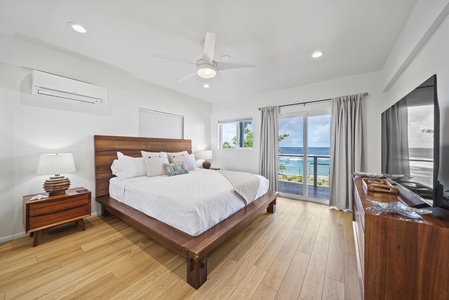 Ocean-view bedroom featuring a cozy California king bed and private access to the balcony—wake up to the soothing sound of waves.